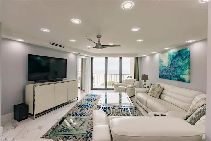 Living area featuring expansive windows, ceiling fan, and recessed lighting