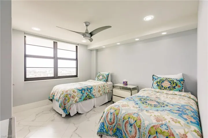 Bedroom featuring ceiling fan, light marble finish floors, and recessed lighting