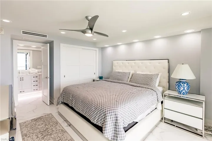 Bedroom with recessed lighting, a ceiling fan, a closet, and light marble finish flooring