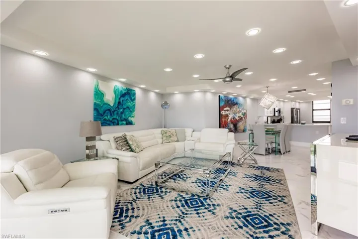 Living room featuring a ceiling fan, light marble finish floors, and recessed lighting