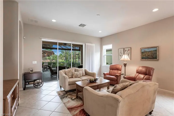 Living room with a sunroom, recessed lighting, and light tile patterned flooring