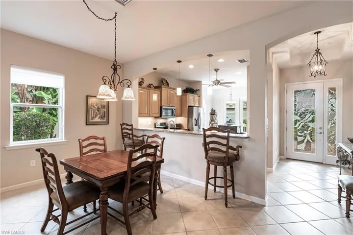 Dining room featuring a chandelier, light tile patterned flooring, recessed lighting, and arched walkways
