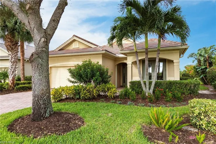 View of front of property with a garage, stucco siding, driveway, and a front yard