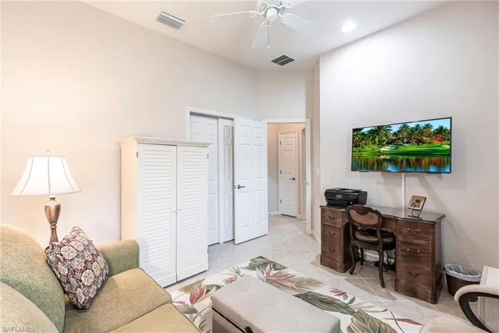 Office area with a towering ceiling and a ceiling fan