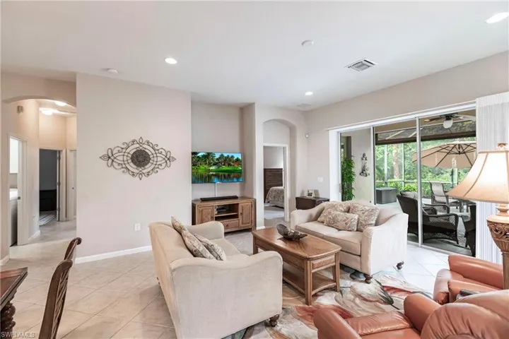 Living room featuring arched walkways, recessed lighting, and light tile patterned floors