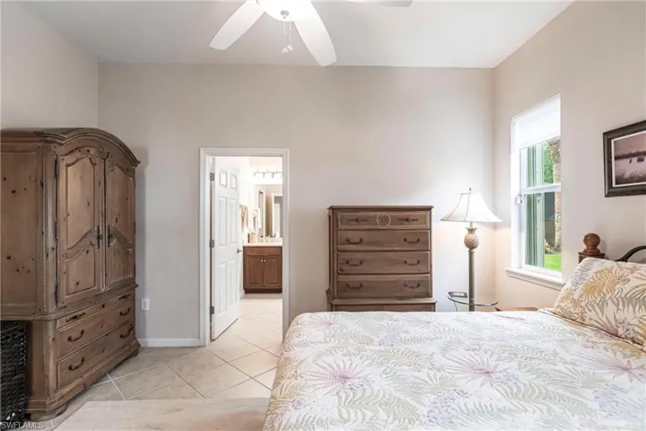 Bedroom featuring a ceiling fan, connected bathroom, and light tile patterned floors
