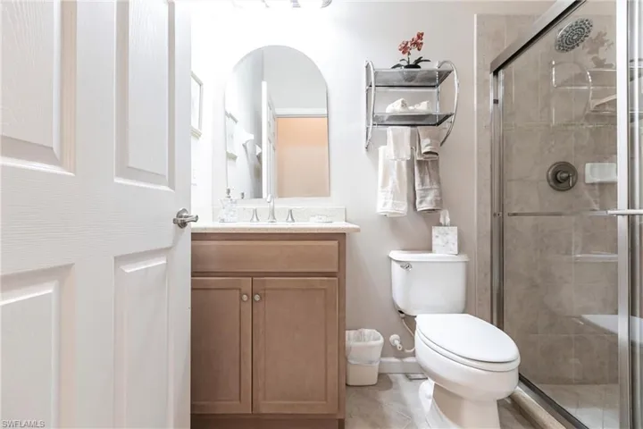 Full bathroom with vanity, a stall shower, and light tile patterned floors