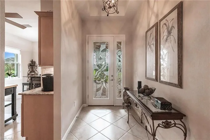 Foyer entrance featuring light tile patterned floors and a chandelier