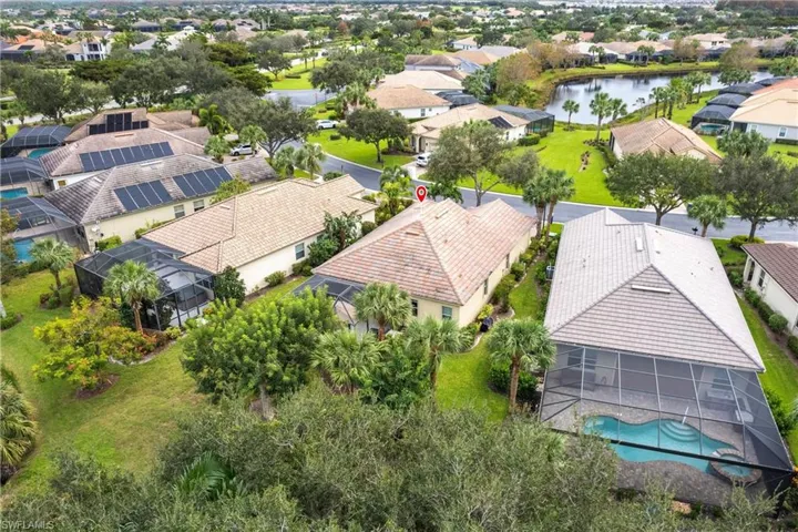 Aerial perspective of suburban area featuring a nearby body of water and a pool