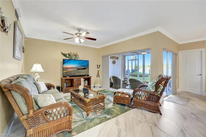 Living area featuring crown molding and ceiling fan
