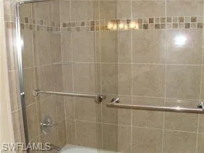 Guest Bath featuring bath / shower combo with glass door