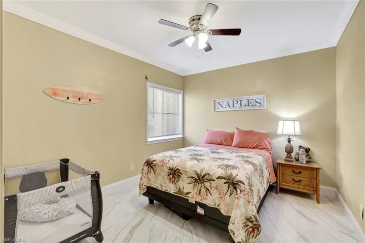 Guest Bedroom with crown molding and ceiling fan, large walkin closet