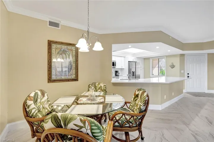 Dining area featuring ornamental molding, a chandelier, and recessed lighting