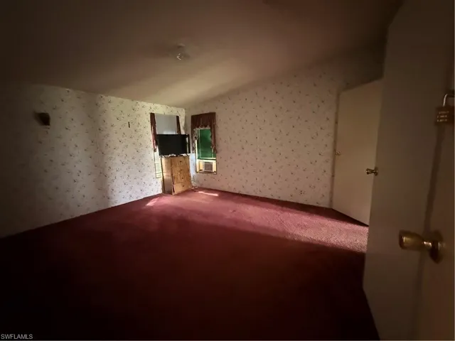 Unfurnished room with carpet and wallpapered walls