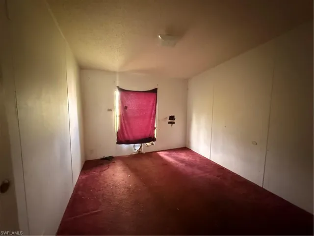 Unfurnished room featuring carpet and a textured ceiling