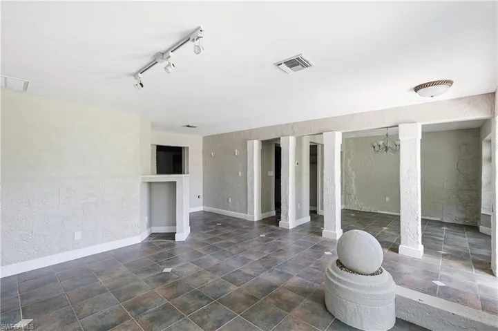 Spacious interior featuring multi-toned square floor tiling and white baseboards