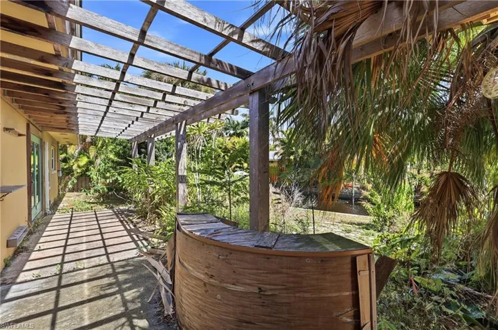 Outdoor patio with an extensive wood pergola providing partial shade