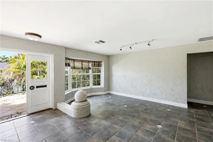 Spacious entryway featuring large format floor tiling, a bay window with natural light, and a built-in stone accent
