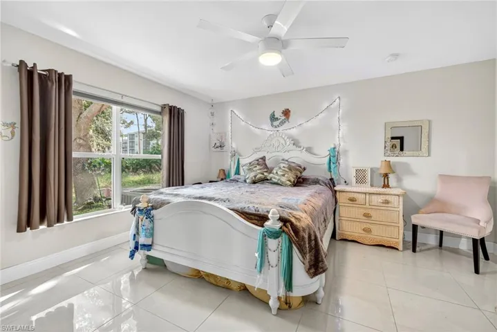 Bedroom with light tile patterned floors and ceiling fan