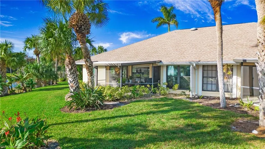 Back of house featuring a yard and a sunroom