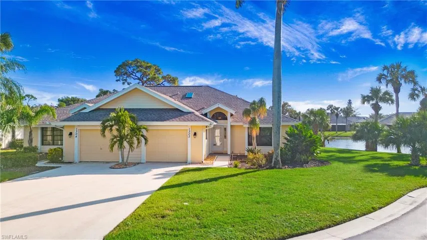 Ranch-style home with a front yard, a garage, and a water view