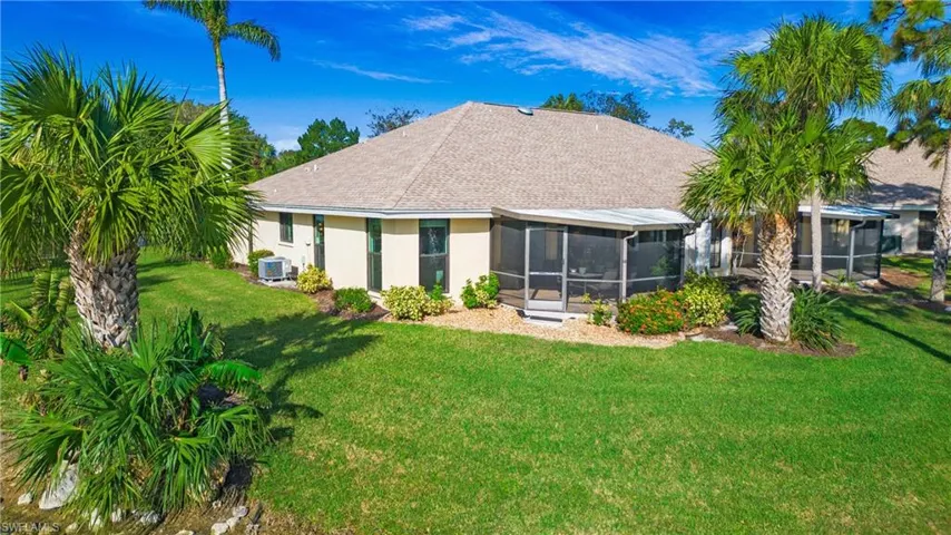 Back of house with a yard and a sunroom