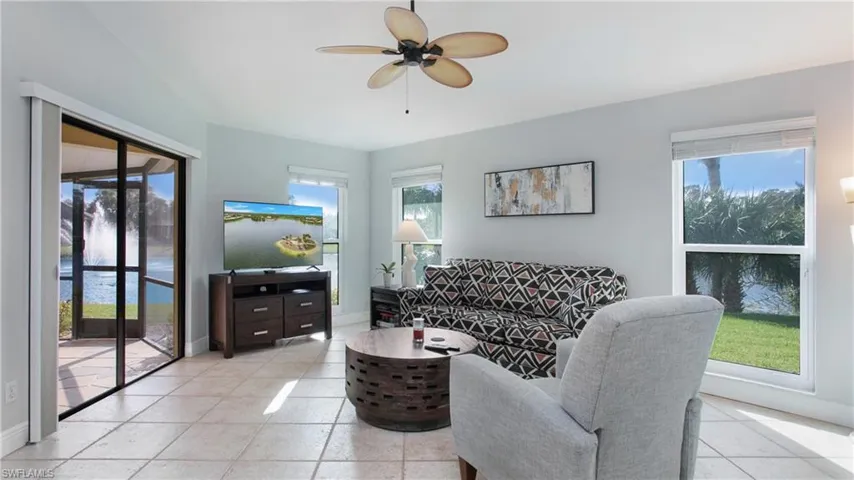 Tiled living room featuring ceiling fan and plenty of natural light
