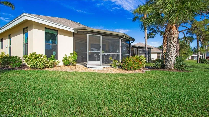 Back of house featuring a yard and a sunroom