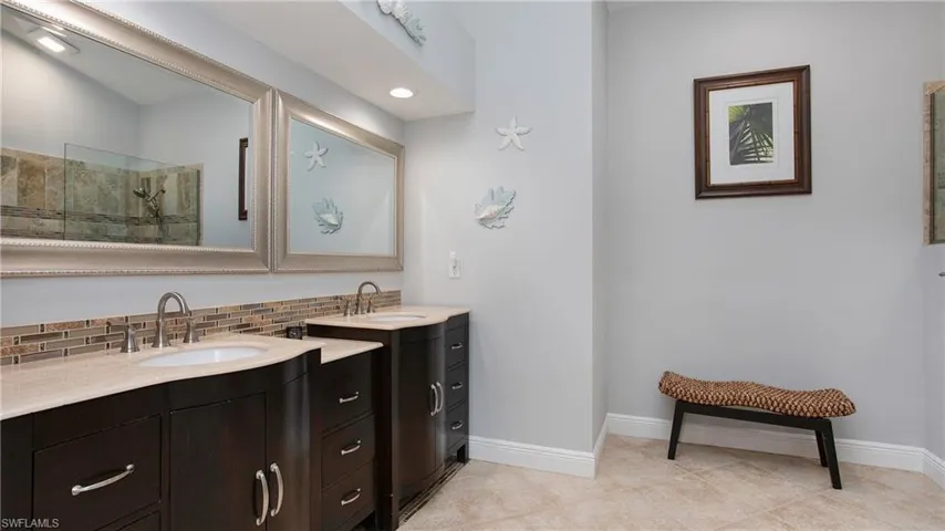 Bathroom with vanity, backsplash, tile patterned floors, and a shower