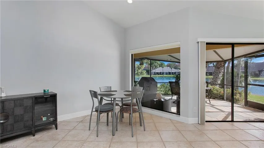 Dining room featuring light tile patterned floors, a water view, and a wealth of natural light