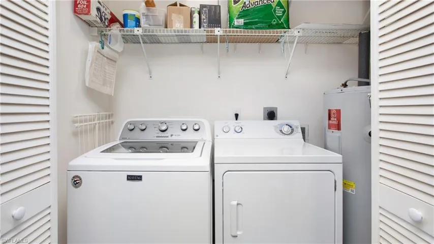Laundry area with water heater and washing machine and clothes dryer