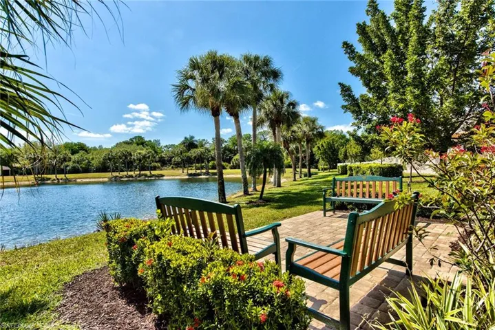 View of home's community with a water view and a lawn