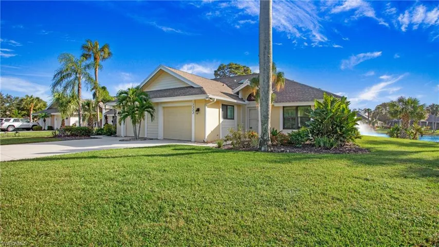 View of front facade featuring a front lawn and a garage