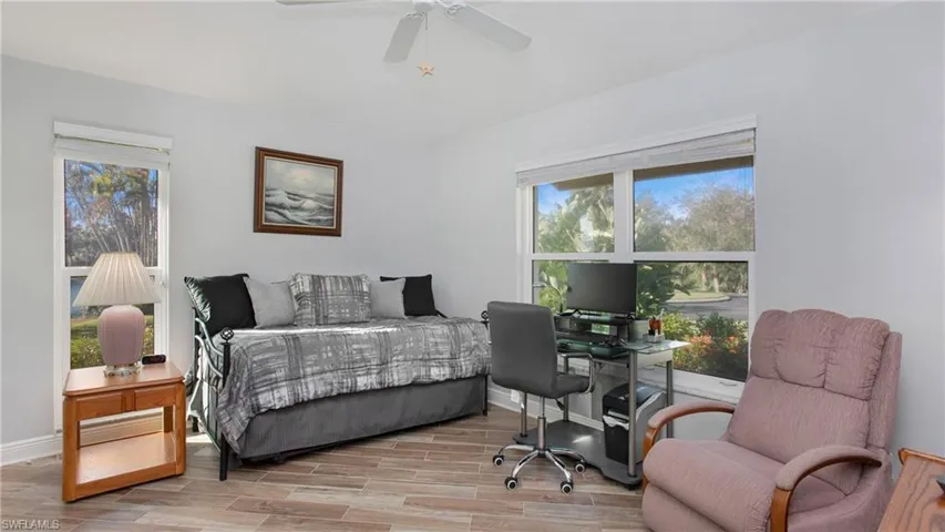 Bedroom featuring multiple windows, light wood-style tile flooring, and ceiling fan