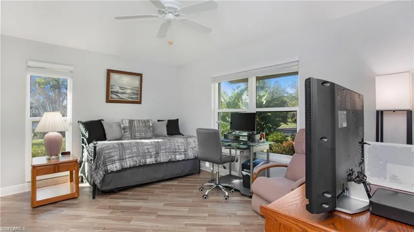 Bedroom with multiple windows, light wood-style tile floors, and ceiling fan