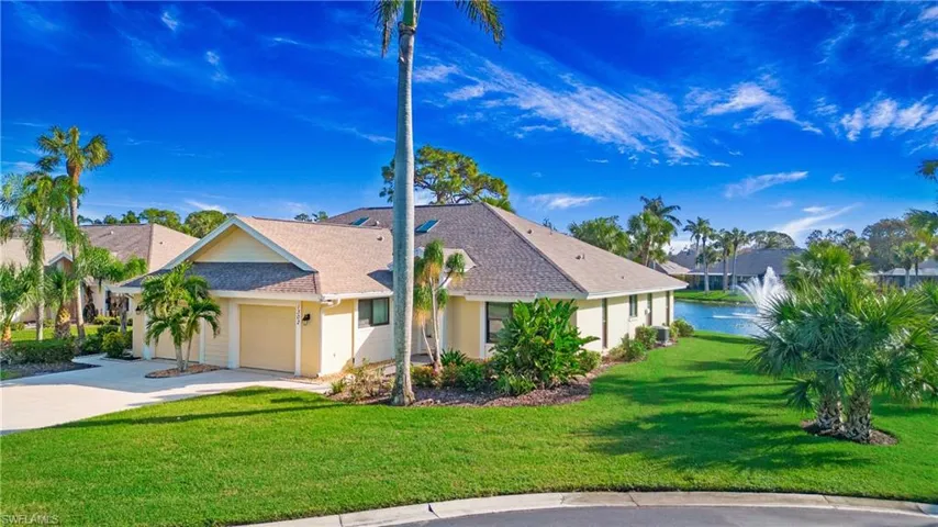 View of front facade with a water view, a front lawn, and a garage
