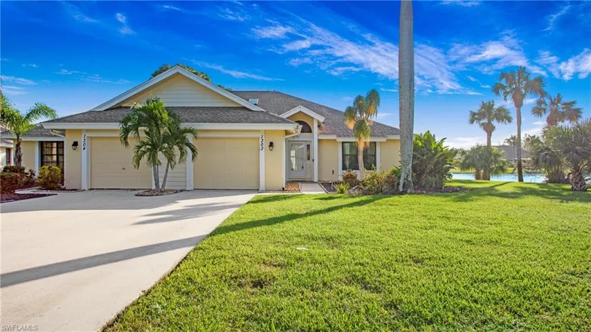 Ranch-style house featuring a garage and a front lawn
