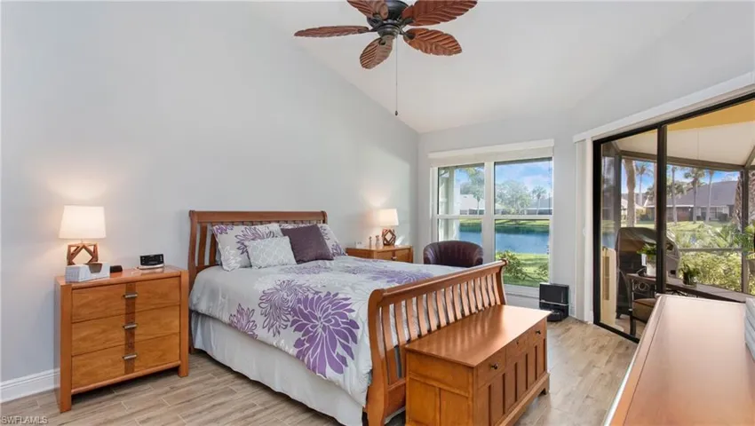 Bedroom with access to exterior, light wood-style tile floors, ceiling fan, a water view, and high vaulted ceiling
