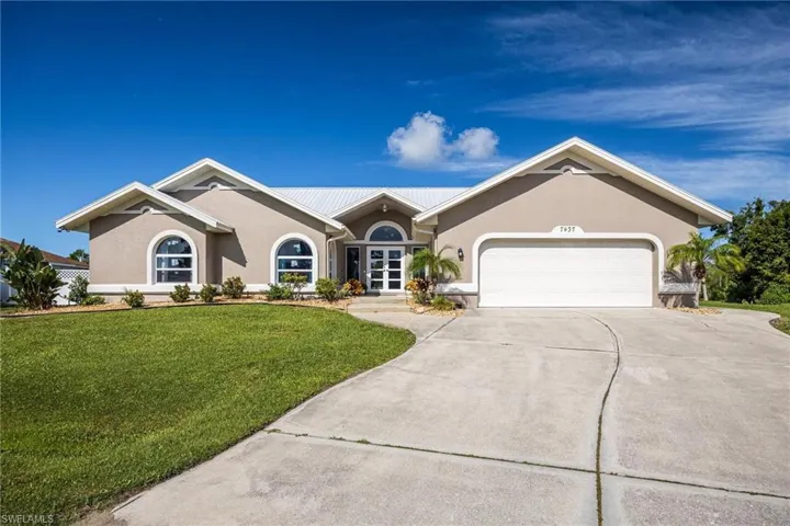 Single story home with a garage and a front lawn
