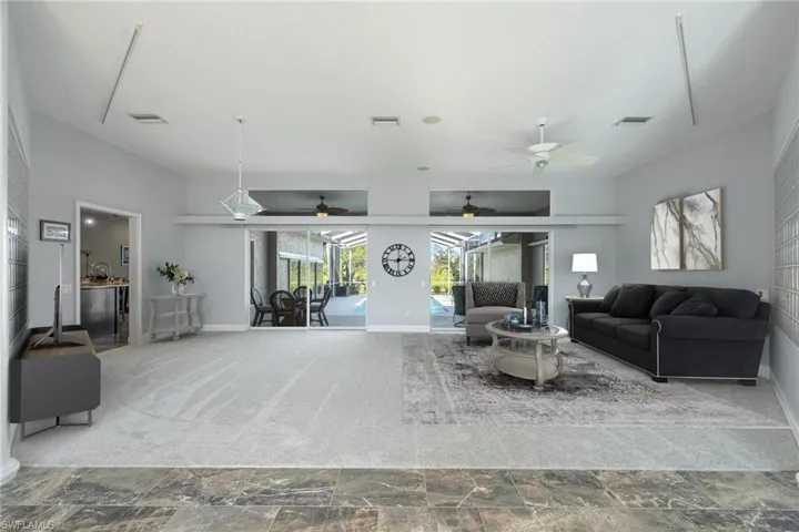 Living room with ceiling fan and tile patterned floors