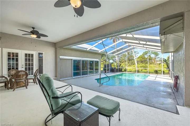 View of pool featuring a patio area, ceiling fan, french doors, and glass enclosure