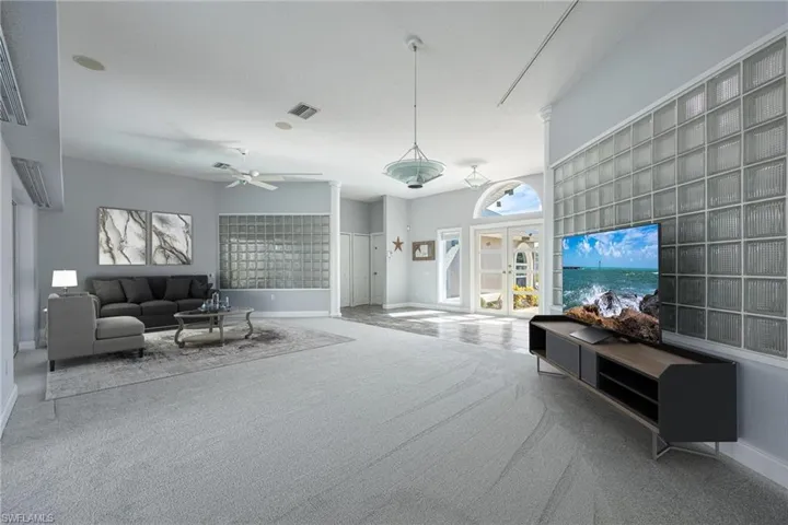 Carpeted living room with ceiling fan