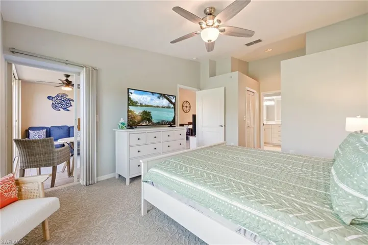 Bedroom with light colored carpet, access to outside, ceiling fan, and connected bathroom