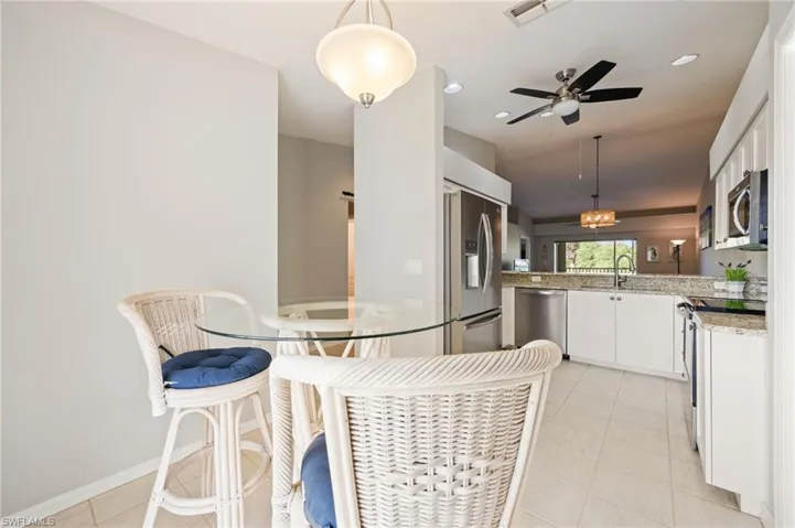 Dining room with light tile patterned floors, a ceiling fan, recessed lighting, and vaulted ceiling