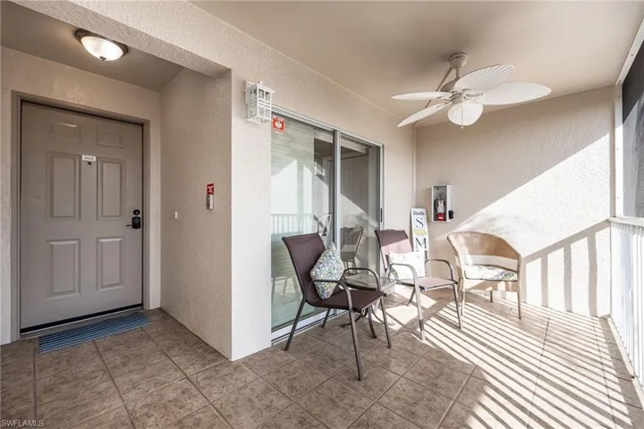 Property entrance featuring ceiling fan, stucco siding, and a sunroom
