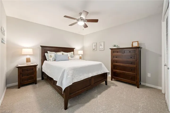 Bedroom with light carpet and a ceiling fan