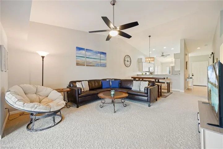 Living room featuring lofted ceiling, light colored carpet, ceiling fan, and recessed lighting