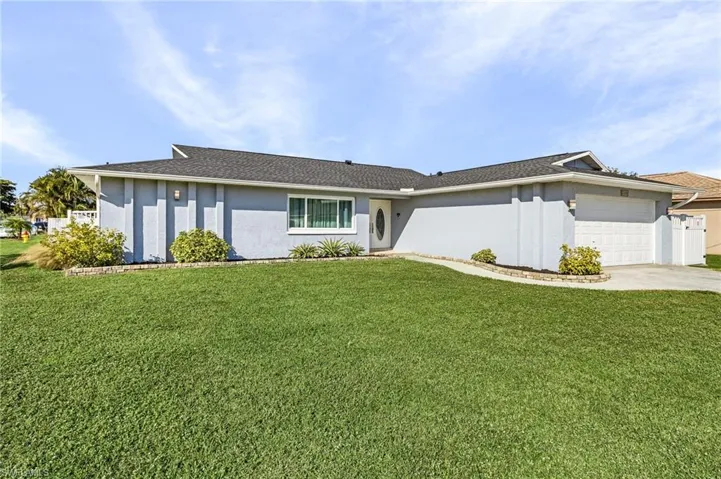 Single story home featuring a front yard and a garage