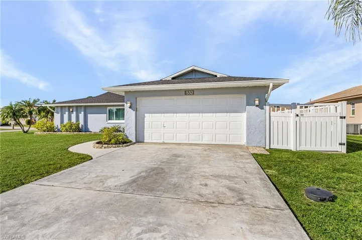 Single story home featuring a garage and a front lawn