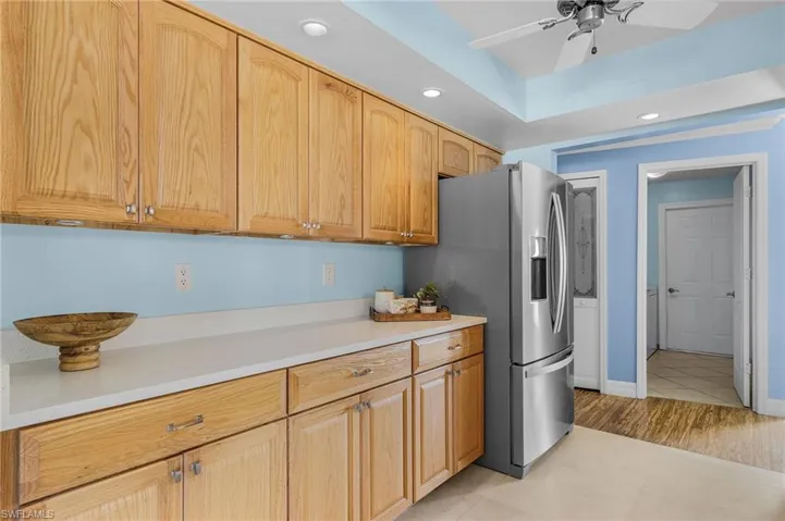 Kitchen featuring stainless steel fridge with ice dispenser, ceiling fan, and light hardwood / wood-style flooring